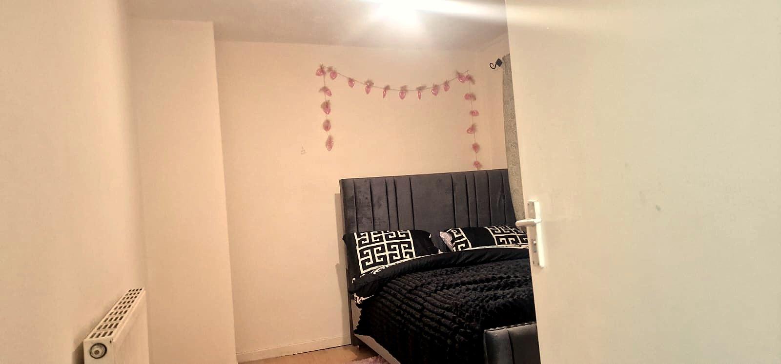 A bright bedroom with a double bed and bunting on the wall