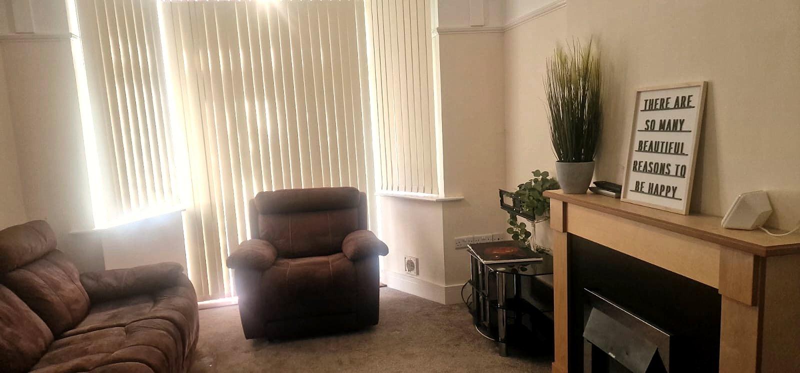 A bright lounge with bay window, sofas and a fireplace