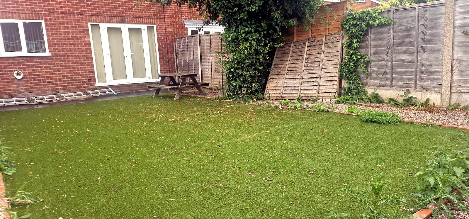 A large private lawn with planting along the fence