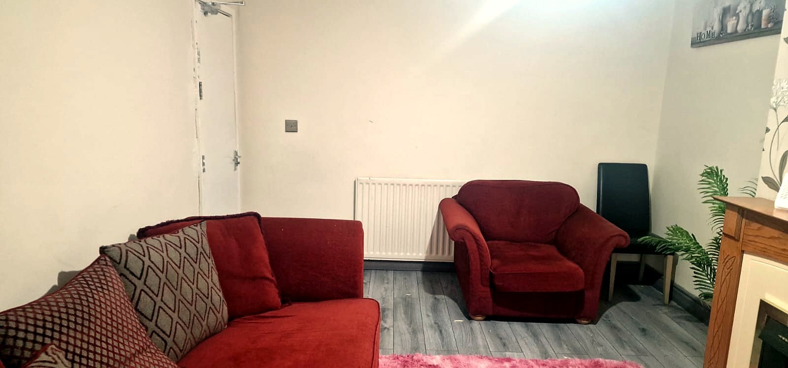 A spacious lounge with a sofa, armchair and fireplace